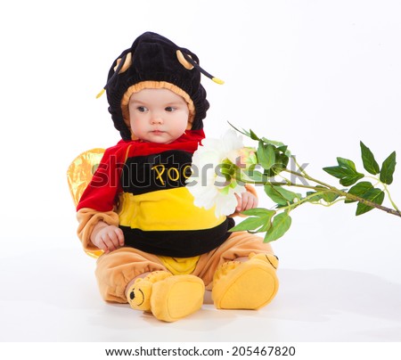 little girl sitting on the floor in a suit bees, turning away from the flower, isolated on white background