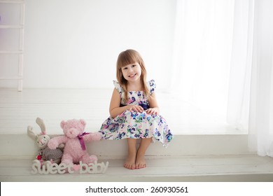 Little Girl Sitting On The Steps With Toys