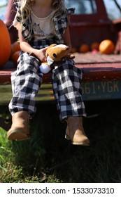 Little Girl Sitting On The Tailgate Of An Old Red Pickup Truck.