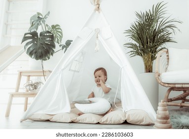 Little girl sitting in a wigwam at home