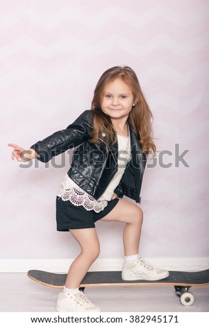a little girl with a skateboard in a leather jacket on a light background Stock photo © 