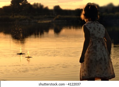 Little Girl Skipping Rocks On Pond At Sunset