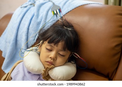 A Little Girl Is Sleeping And Doing A Neurofeedback Exam. Making EEG Electrodes.