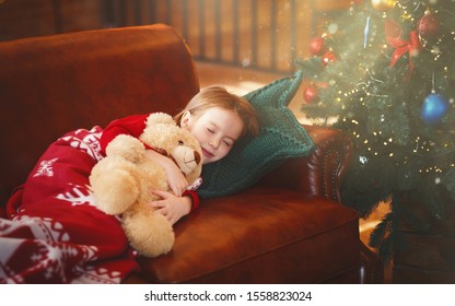 Little Girl Sleeping Next To Shining Xmas Tree, Hugging Teddy Bear, Magic Happens During Christmas Night, Free Space