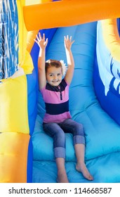 Little Girl sliding down an inflatable Slide