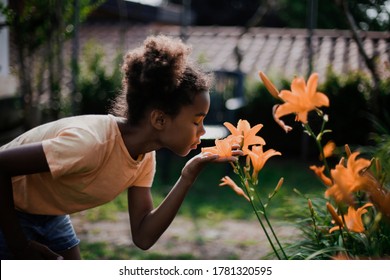 Little Girl Is Smelling Flowers