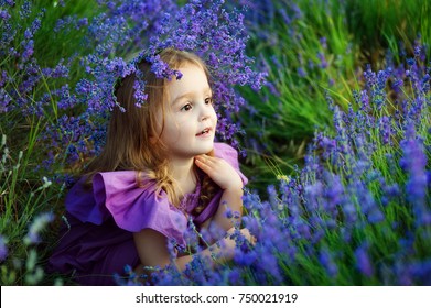 Little Girl Smelling Flowers In The Meadow