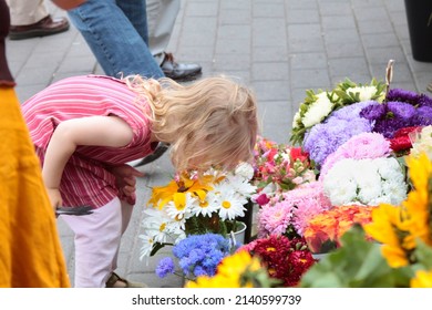 A little girl smelling flowers on a flower market. Selective focus. High quality photo