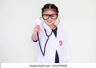 A little girl smiling, dressed in a Doctor. Doctor headphones handle up poses check.