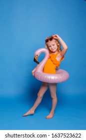 a little girl smiling in a swimsuit and sunglasses and an inflatable circle on a pink background. Travel concept - Shutterstock ID 1637523622