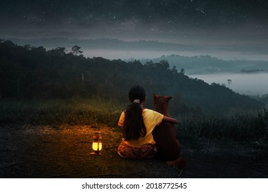 A Little Girl Snuggled Up To Her Dog And Watched The Stars At Night Alone By The Light Of The Lantern.