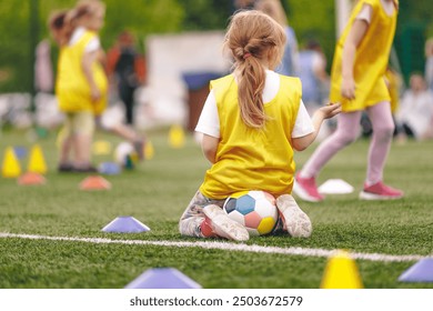 Little Girl in Soccer Training. Football Practice for School Kids. Female Soccer Team in Training Drill at School Soccer Pitch - Powered by Shutterstock