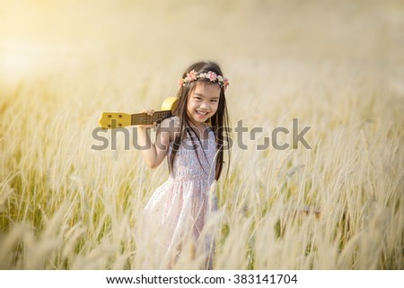 Little girl standing on meadow with sunset