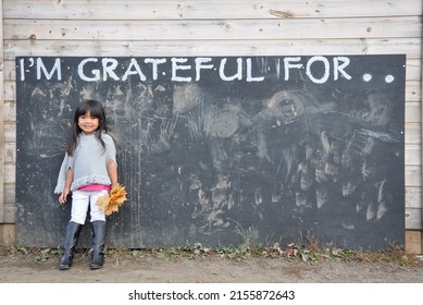 Little Girl Standing In The Wall With I'm Grateful For Sign