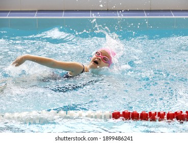 kleines Mädchen, das im Schwimmbecken schwimmt