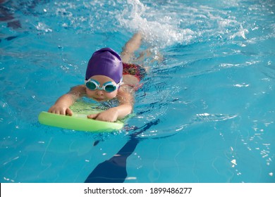 little girl swimming in the pool at the training in swimming