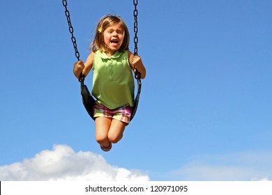 Little girl swinging high above clouds