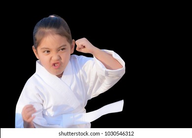 Little Girl In Taekwondo Outfits Acting Fight Isolated On Black Background