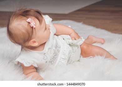 little girl with a tail on her head crawling on the floor