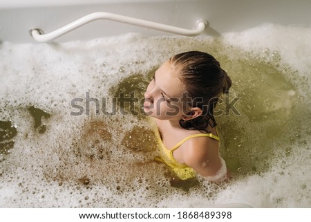 a little girl takes the procedure in a mineral bath. The patient receives water treatments with a mineral pearl bath
