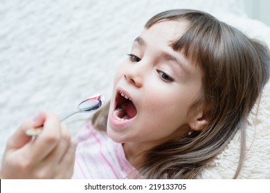 Little Girl Taking Medicine With Spoon