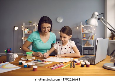 Little Girl Taking Online Art Class With Mother Helping Her At Home. Child And Parent Drawing Together To Video Tutorial