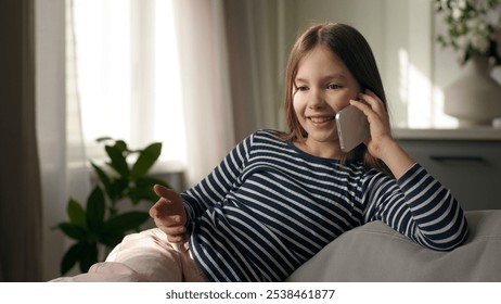 Little girl talking mobile phone smartphone telephone laughing smile communicate call chatting conversation home child kid daughter technology gadget gossip distance dialogue connection contact enjoy - Powered by Shutterstock