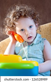 Little Girl Talking On A Toy Phone