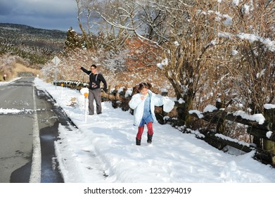 Little Girl And Teenage Boy (mixed Race Brazilian And Japanese) Playing Snowball Fight. Shizuoka Prefecture, Japan. Winter Of February 2011.