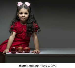 Little Girl With Three Pomegranates In Front Of Her. Happy Yalda Iranian Celebration Theme