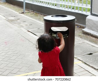 Little Girl Throw Rubbish Into Rubbish Bin On Public Area. Role Model Concept