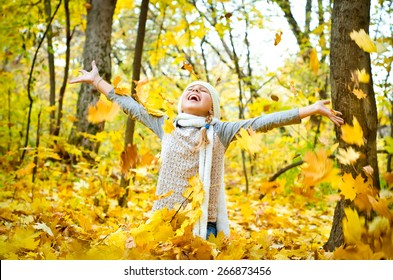 Little Girl Throwing Autumn Leaves