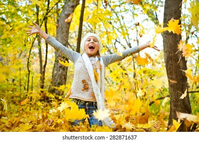 Little Girl Throwing Autumn Leaves