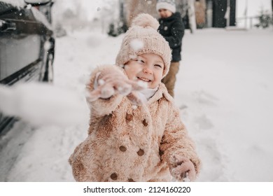 Little Girl Throws A Snowball In Her Face. High Quality Photo