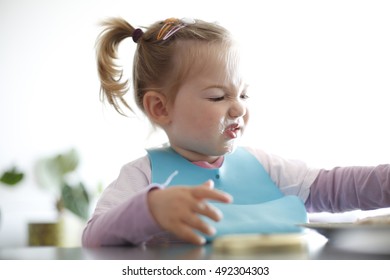 Little Girl Toddler Picking Her Food, Making Faces. Childhood Problems, Picky Eater, Eating Habits, Terrible Two Concept. 
