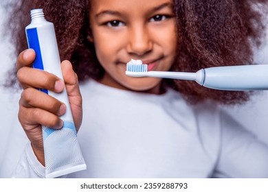Little girl toothbrush closeup. Little cute african american girl brushing her teeth. Healthy teeth, toothpaste. Small girl, toothbrush. Multiracial girl brushes her teeth an electric toothbrush.
