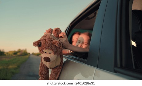 little girl with toy bear. happy face child daughter from window with teddy bear. happy family. mother daughter traveling car. happy mother child back seat car going trip. face childish smile. - Powered by Shutterstock