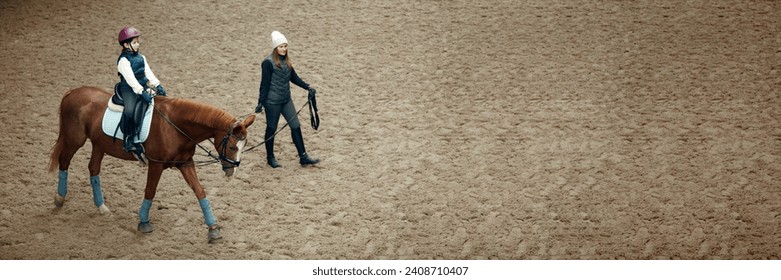 Little girl training, practicing horseback riding with instructor. Teacher teaching equestrian. Concept of sport, childhood, school, course, active lifestyle, hobby. Banner. Empty space for ad - Powered by Shutterstock