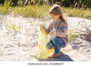  Little Girl With Trash Bag Cleaning Up The Beach. Child Collects Plastic, Garbage On The Beach By The Sea.