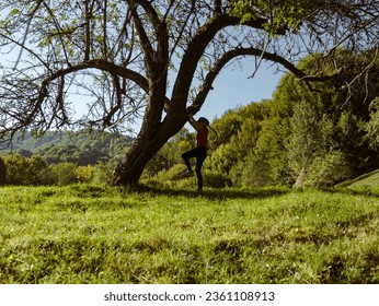 Little girl traveler climbing on tree forest Carpathian mountains peak Zakarpattya village, Ukraine, Europe. Child walks on green lawn scenic landscape sunny day. Eco Local countryside tourism. Hiking - Powered by Shutterstock