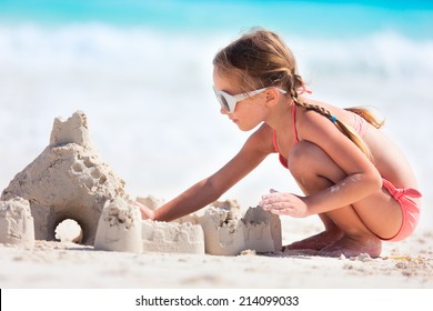Little Girl At Tropical Beach Making Sand Castle