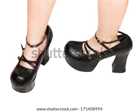 little girl trying on black platform shoes her mother