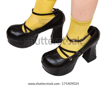 little girl trying on black platform leather shoes older sister