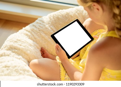 Little girl using tablet computer at home