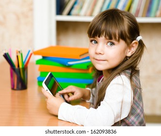 little girl using tablet computer. looking at camera - Powered by Shutterstock