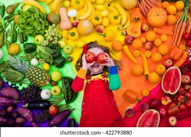 Little Girl With Variety Of Fruit And Vegetable. Colorful Rainbow Of Raw Fresh Fruits And Vegetables. Child Eating Healthy Snack. Vegetarian Nutrition For Kids. Vitamins For Children. View From Above.