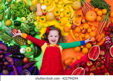 Little Girl With Variety Of Fruit And Vegetable. Colorful Rainbow Of Raw Fresh Fruits And Vegetables. Child Eating Healthy Snack. Vegetarian Nutrition For Kids. Vitamins For Children. View From Above.