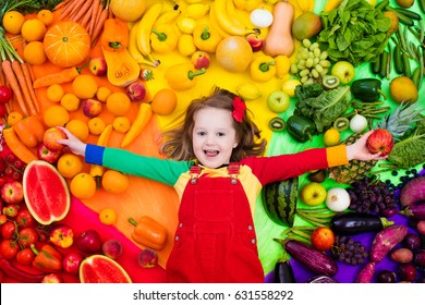 Little Girl With Variety Of Fruit And Vegetable. Colorful Rainbow Of Raw Fresh Fruits And Vegetables. Child Eating Healthy Snack. Vegetarian Nutrition For Kids. Vitamins For Children. View From Above.