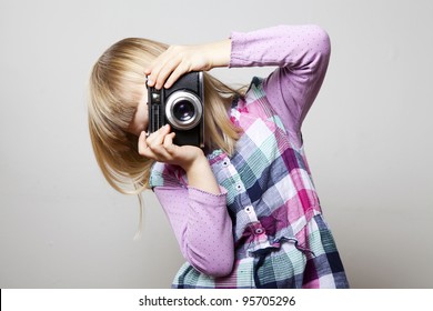 Little Girl With A Vintage Camera. Studio Shot.