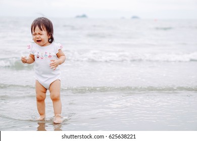 Little Girl Walk And Cry With Waves On The Beach.baby Girl Scary Sand.